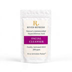 River Refresh Hypochlorous Acid Spray Facial Cleanser Refill Kit n a white resealable pouch with a cream label, featuring a purple banner and gold logo, set against a solid pink background.