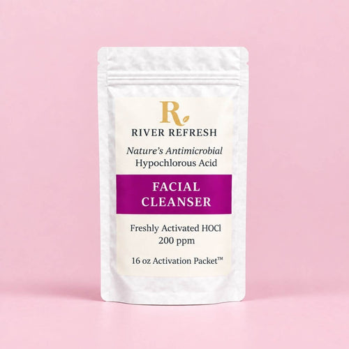 River Refresh Hypochlorous Acid Spray Facial Cleanser Refill Kit n a white resealable pouch with a cream label, featuring a purple banner and gold logo, set against a solid pink background.