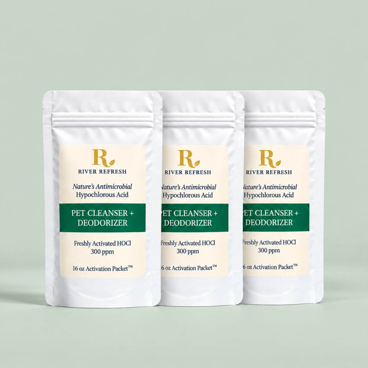 Three white stand-up pouches of River Refresh Pet Cleanser + Deodorizer are arranged in a row against a solid sage green background.